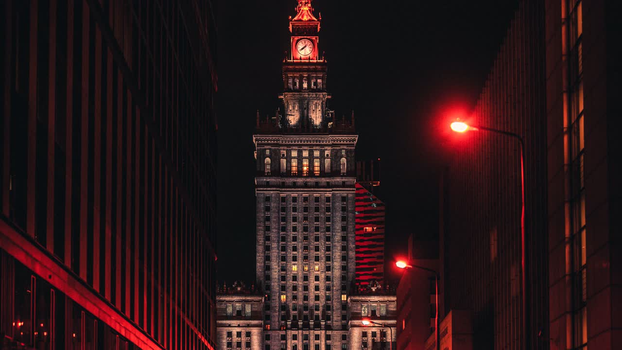 Wieża Pałacu Kultury i Nauki nocą, widziana z ulicy oświetlonej na czerwono